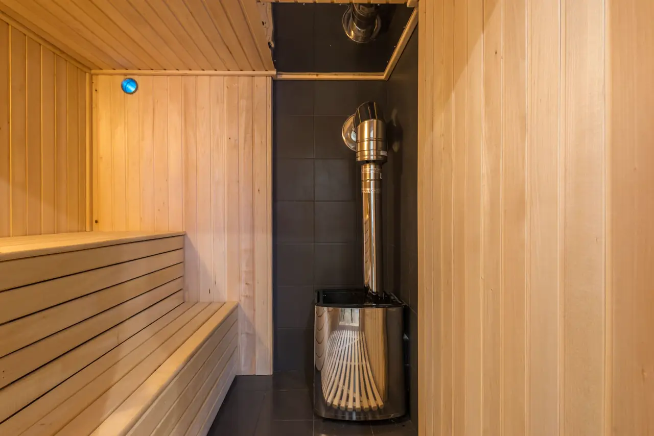Cedar benches and a heater inside a finished sauna.